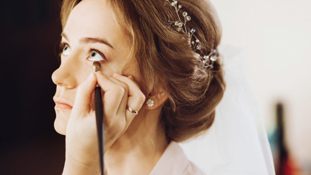 Bride having eye liner applied