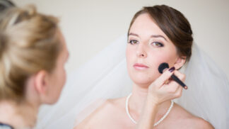 Bride having her make up touched up by her make up artist