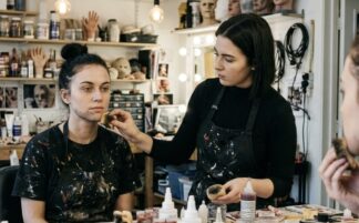 Stubble make up being applied to a model in a make up room